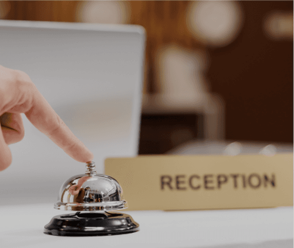 Reception desk bell beside a reception sign